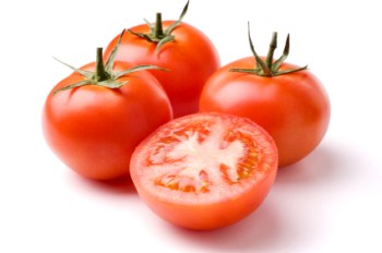 Ripe red tomatoes on a white background with clipping path. The focus is on the sliced tomato in front.